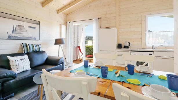 Ein gemütliches Blockhauss-Interieur mit Essbereich, einer Couch und einer Küche.