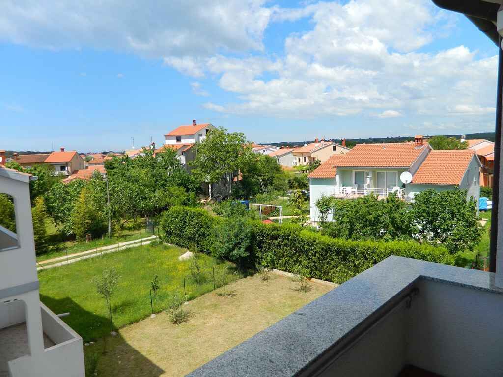 A residential area with houses, a well-maintained lawn, and a clear sky.