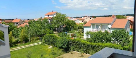 A residential area with houses, a well-maintained lawn, and a clear sky.