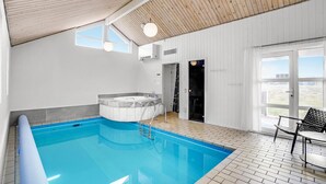 A modern indoor swimming pool with a hot tub, wooden ceiling, and large windows. - Gorgeous home in Thisted with sauna (Thisted)