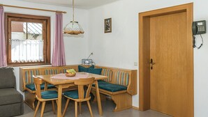 A cozy dining area with a wooden table and bench, a vintage radio, and a telephone on the wall. - Ferienwohnung mit Lift (Rauris)