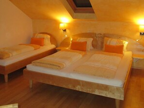 A hotel room with two beds, a skylight, and wall-mounted lamps.