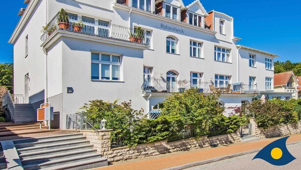 A white building with balconies, named "Rolandseck," featuring a stone staircase and surrounding greenery. - Rolandseck I, Apt. 04 - A Little Oasis Near the Beach - RO I 04 (Heringsdorf)