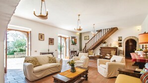 A spacious living room with a high ceiling, a staircase, and a view of greenery outside. - 4 bedroom nice home in Terni TR (Terni TR)