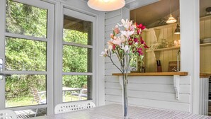 A dining area with a table, chairs, and a vase of flowers. - 2 bedroom stunning home in Græsted (Græsted)
