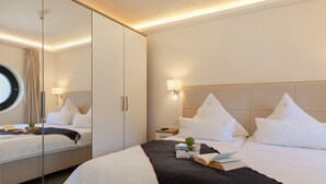 Ein Hotelzimmer mit Bett, Nachttisch, Spiegel und einem Fenster mit Vorhängen.