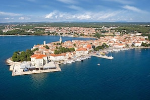 Vue aĂ©rienne dâune ville cĂŽtiĂšre avec un port de plaisance, des bĂątiments historiques et un clocher dâĂ©glise imposant.