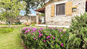 A stone house with a garden featuring vibrant pink flowers. - Lovely home in Cukrici with WiFi (Cukrici)