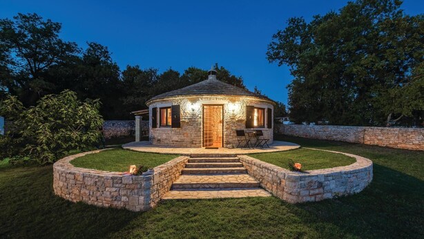 A stone cottage with a wooden door, a small porch, and a stone wall surrounding the property. - Lovely home in Cukrici with WiFi (Cukrici)