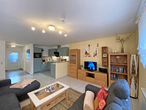 Un salon moderne avec un canapé, une table basse et un téléviseur.