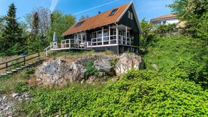 Ein Haus mit schrägem Dach, einem Balkon und einer Treppe, die darauf führt.