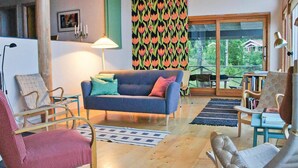 A cozy living room with a blue sofa, patterned cushions, and a wooden floor. - Beautiful home in Smålandsstenar (Smålandsstenar)