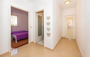 A hallway with a bed, a door with heart-shaped decorations, and a tiled floor. - Pet friendly apartment in Rogoznica with WiFi (Rogoznica)