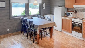 Une cuisine compacte comprenant un coin repas, un réfrigérateur, un four à micro-ondes et une cuisinière.
