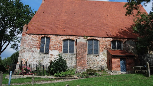 A historic building with a red-tiled roof and stone walls, featuring arched windows and a small porch. - Sunshine house in Baabe - holiday home (Baabe)
