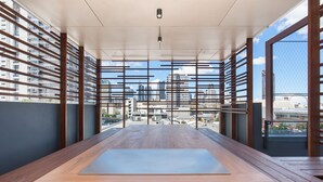 A modern, open-plan room with a large wooden table and a city view through large windows. - Ivy and Eve Apartments by CLLIX (South Brisbane)