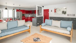 Ein modernes Wohnzimmer mit zwei Sofas, einem Holztisch und einer Küche im Hintergrund.