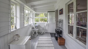 A white-paneled room with a table and chairs, a ladder, and a wicker basket. - 3 bedroom stunning home in årjäng (Årjäng)