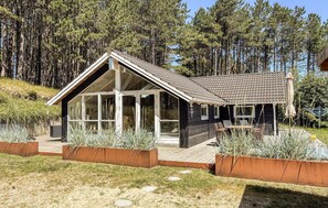 A modern cabin with a sloped roof, large windows, and a deck. - Lovely home in Rømø with sauna (Rømø)
