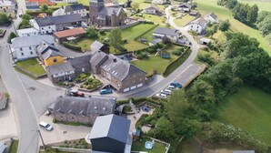 An aerial view of a residential area with houses, a church, and a playground. - Stunning home in Burg Reuland/Steffesh. (Burg Reuland/Steffesh.)