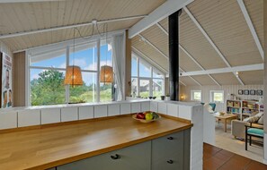 Enjoy a meal with a view from this kitchen, featuring a large window and a cozy seating area.