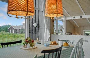 Enjoy a romantic dinner for two at this stylish dining area, featuring a beautifully set table with a vase, a plate, and a small container.