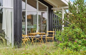 Enjoy dining or socializing in this outdoor seating area surrounded by lush greenery.