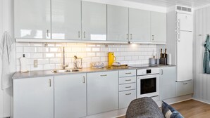 A modern kitchen with white cabinets, a stainless steel sink, and a built-in oven. - Amazing home in Pandrup with WiFi (Pandrup)