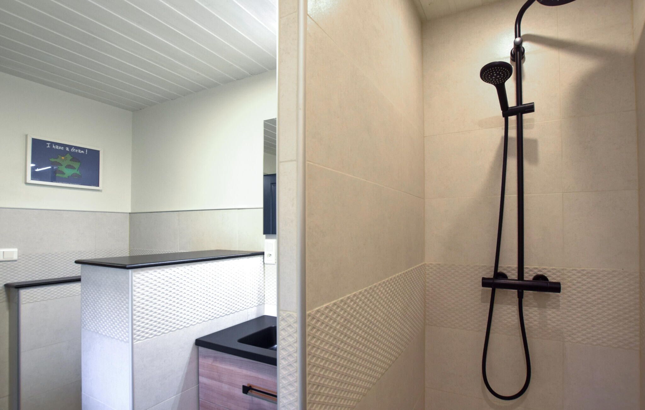A bathroom with a shower, a sink, and a cabinet.
