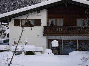 Un edificio di due piani con un balcone, imbiancato dalla neve.