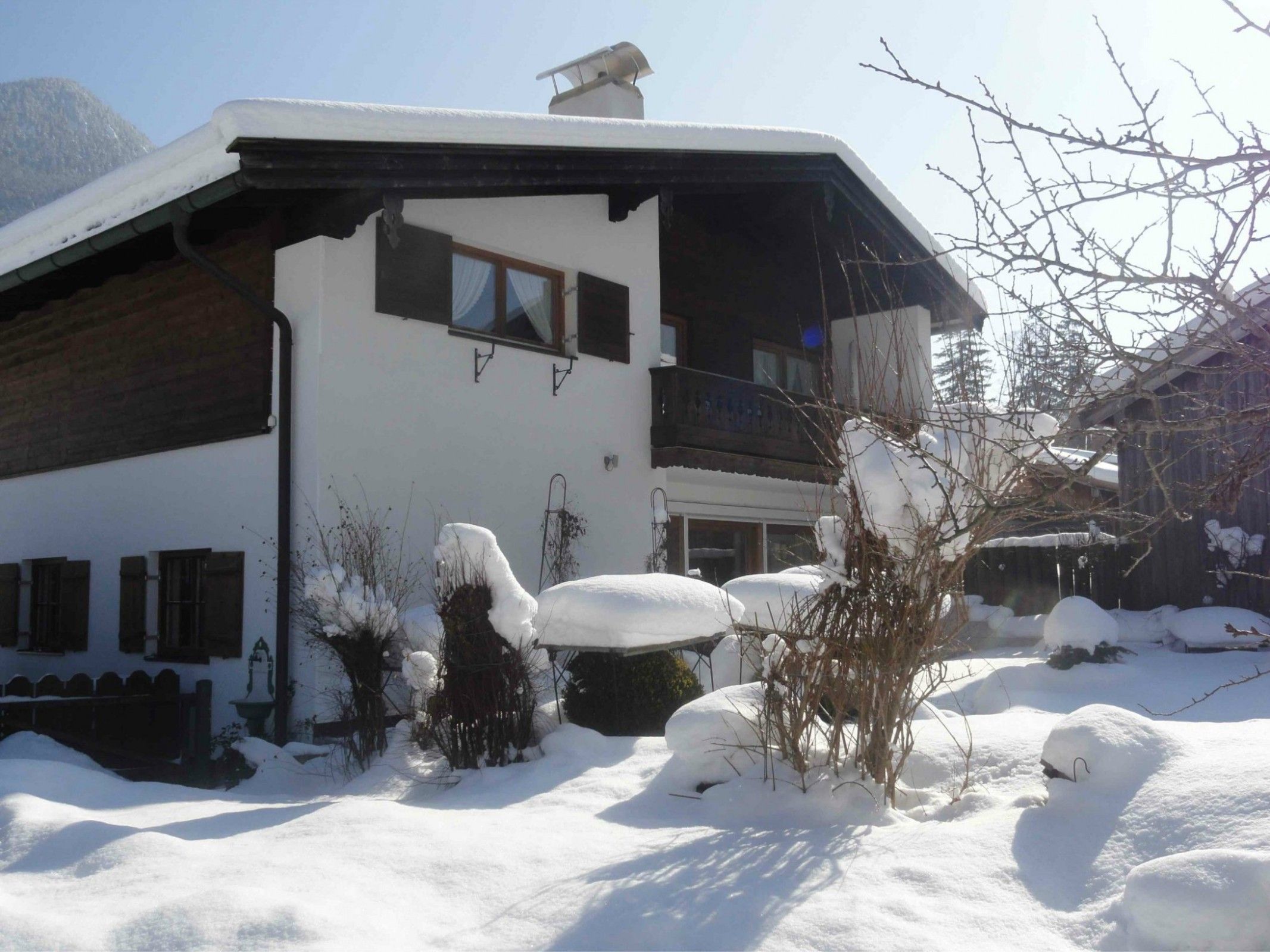 Un bâtiment à deux étages, doté d’un toit en pente, d’un balcon et d’une cheminée.