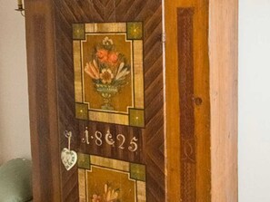 A wooden door with a decorative panel featuring a floral design and the number 'i.8c25'. - House Strillinger, Kreuth-Riedlern - Vacation Apartment Strillinger (Kreuth)