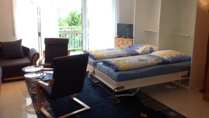 A bedroom with a bed, a chair, a desk, a wardrobe, and a TV. - Vacation apartment on Lake Mirower See (with balcony) left Whg.2 - Ferienwohnungen am See (Mirow)