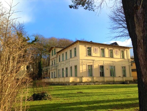 Un grand bâtiment à deux étages, doté d’une façade symétrique, de nombreuses fenêtres et d’une entrée centrale.