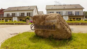 Ein großer Felsen mit dem Schriftzug 'elbresort' vor einer Reihe von Häusern mit Balkonen.
