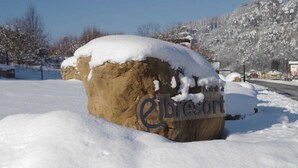 Ein großer Felsen mit der Inschrift 'Elbriscoft' in verschneiter Landschaft.