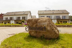 Uma grande rocha com o texto 'elbresort' em frente a uma fileira de casas com varandas.
