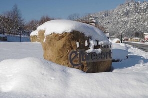 Uma rocha grande com a inscrição 'Elbriscoft' em uma paisagem nevada.