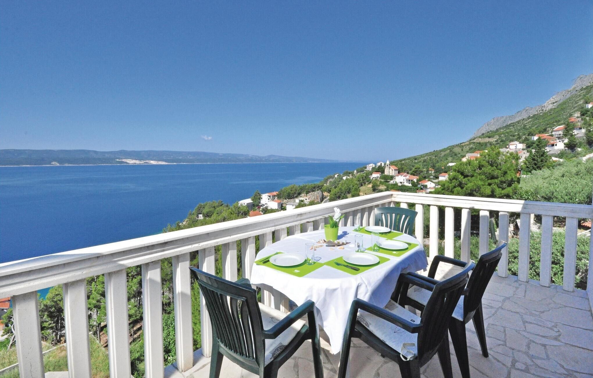 A table set for two with a view of the sea and hills in the background.