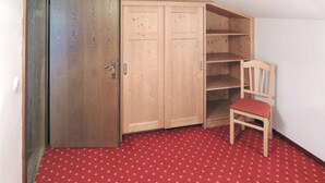 Une pièce comprenant une armoire, une chaise et un tapis à motifs.
