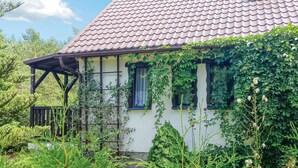 A traditional house with a tiled roof, wooden porch, and ivy-covered walls.