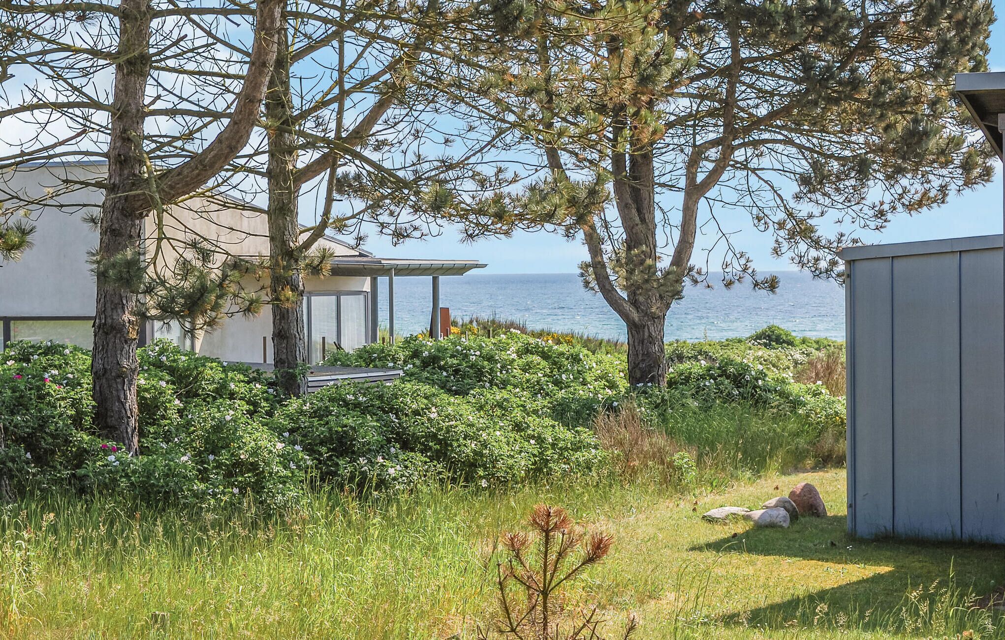 Ein Küsteneigentum mit einem Haus, einem Schuppen und Meerblick.