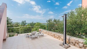 A rooftop terrace with a stone wall, two lounge chairs, and a metal railing. - Holiday apartment with air conditioning and sea view (Klimno)