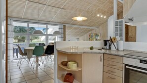 A modern kitchen with a large island, built-in appliances, and a dining area with a view. - Nice home in Jerup with kitchen (Jerup)