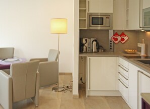 A modern kitchen with a microwave, kettle, and kettle hooks on the wall. - Haus Meeresblick FeWo Regenbogen A 1.19 Ref. 132408 u 1 - FeWo Regenbogen A 1.19 (Baabe)