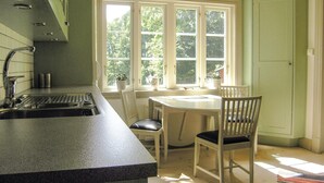 A kitchen with a sink, a window, and a dining table with chairs. - Stunning home in Lidhult with WiFi (Lidhult)