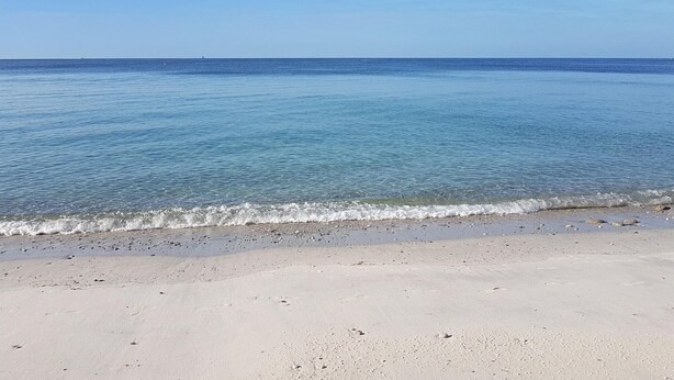 En strand med klart vatten och en sandstrand.