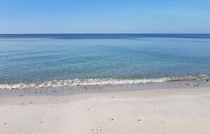 Una playa con agua cristalina y una orilla arenosa.
