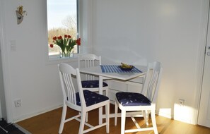 Enjoy meals in this cozy dining area with a table for four, a vase of fresh flowers, and a convenient location.