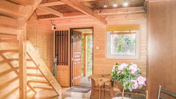 A wooden cabin interior with a staircase, a dining area, and a window with a view of greenery. - 2 bedroom pet friendly home in Karwienskie Blota (Karwienskie Blota)